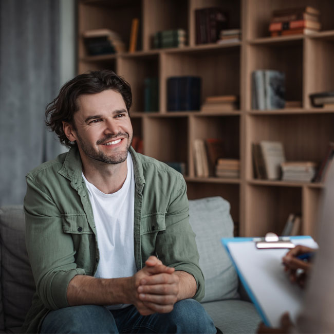 white man sitting in therapist's office, smiling