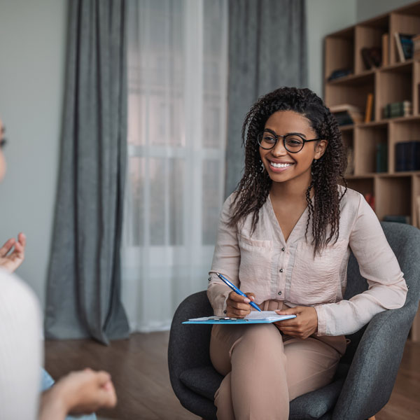 smiling female therapist takes notes